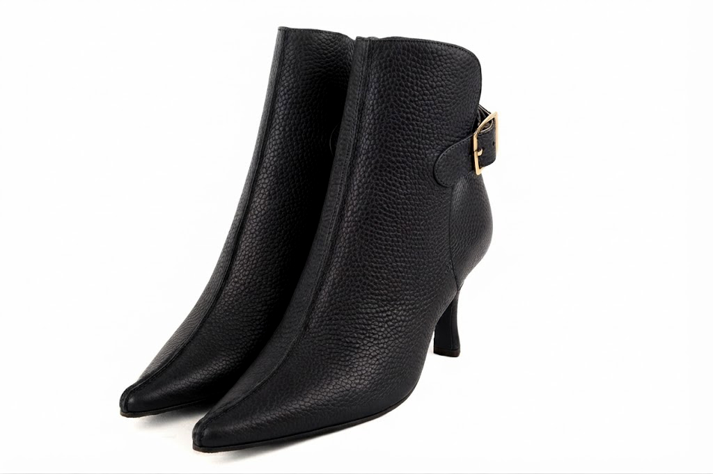Sophisticated leather ankle boots detailed with an elegant back buckle and heel-strap finish for a distinct couture look, in black leather with pointed toe and high spool heel